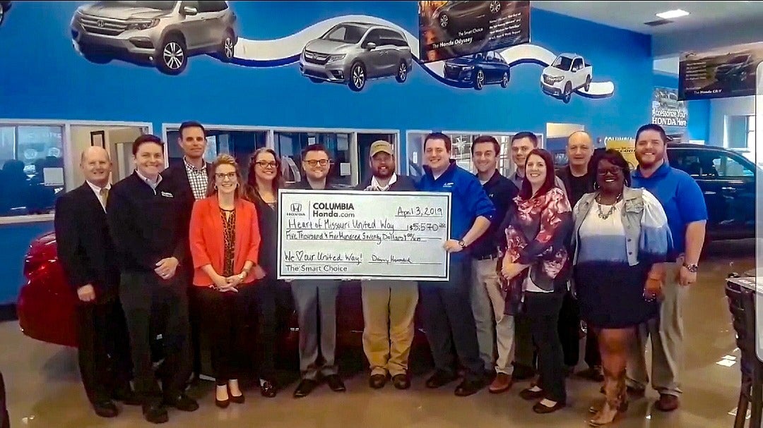 image of employees at Columbia Honda holding up a check